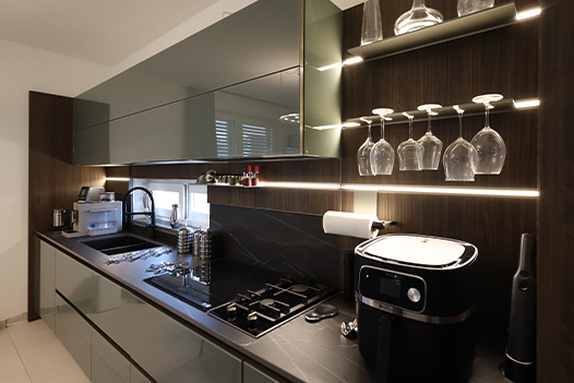 Veneta Cucine con un piano in marmo color legno e venature a vista, spazio per bichieri da vino